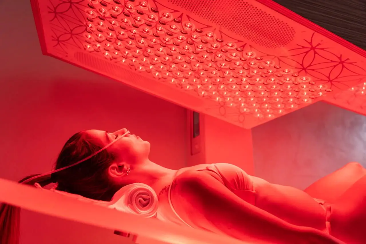 A client reclined under the Ammortal Chamber’s red light array, nasal cannula in place.