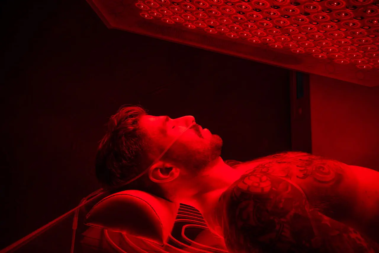 A client mid-session in the Ammortal Chamber, eyes closed under the light array.