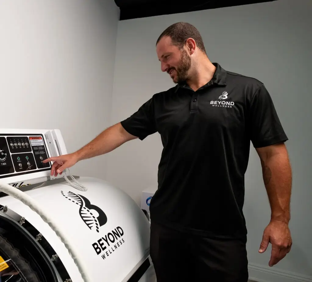 A Beyond Wellness team member setting the control panel on the hardshell hyperbaric chamber.