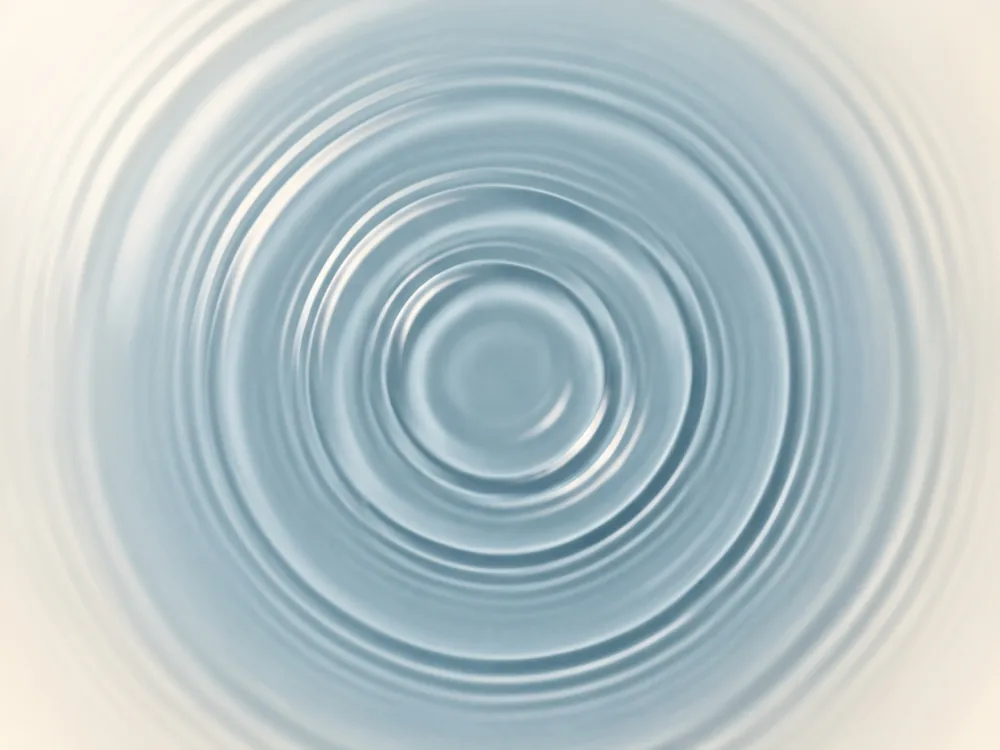 An abstract macro study of concentric ripples across still blue water.